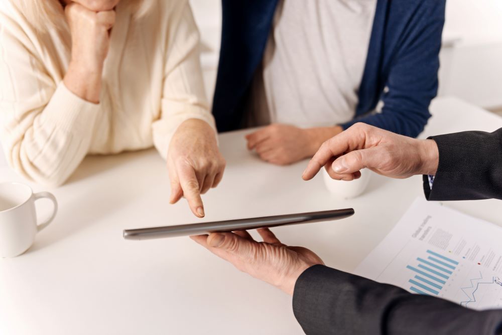 Wealth advisor showing something on a tablet to their clients